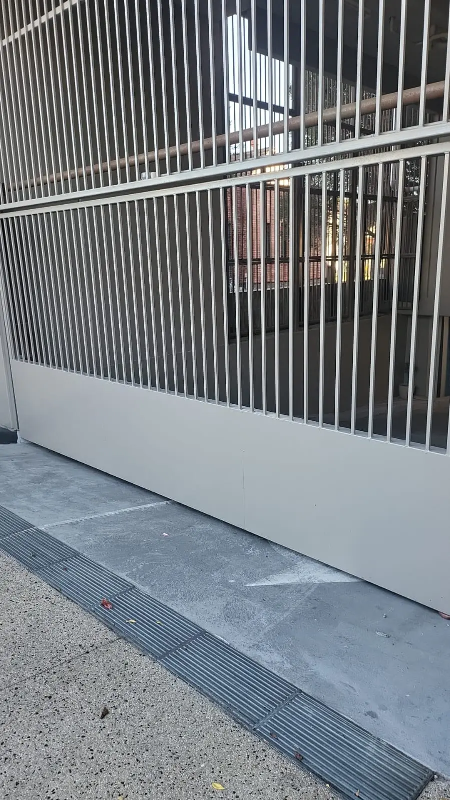 White vertical bar fence panel on rendered base wall